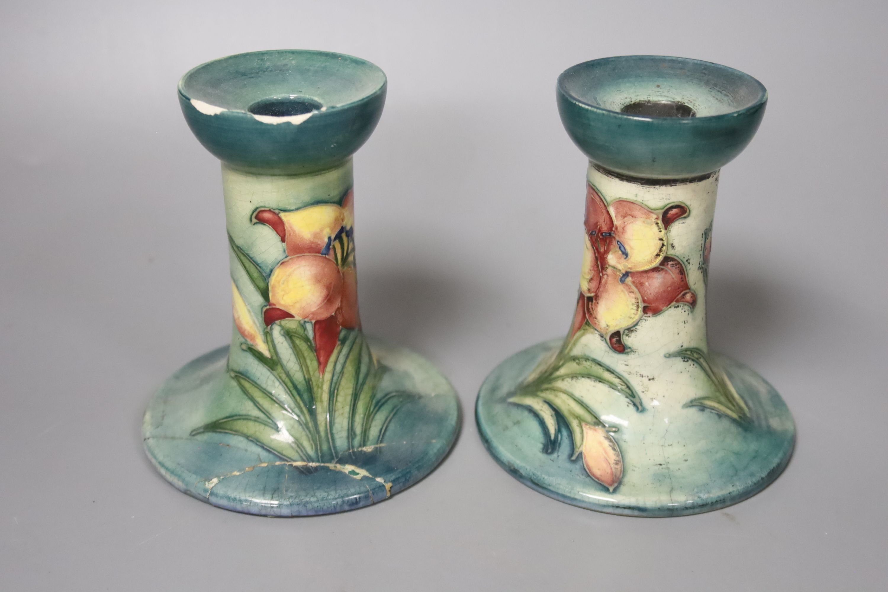 A pair of Moorcroft candlesticks, a jar and cover, and a bowl